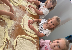 dzieci przygotowują ciasto na pizzę