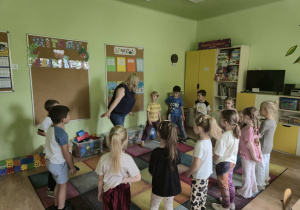 Dzieci stoją w kole z panią psycholog
