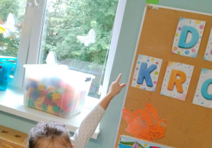 Dziewczynka pokazuje znalezioną w sali kropkę