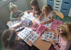 Dzieci wykonują ćwiczenia w kartach pracy.