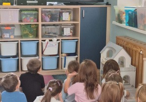 Dzieci oglądają bajkę o postaciach z Wioski Kumplików