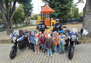 Dzieci pozują do zdjęcia przy policjantach i motorach policyjnych