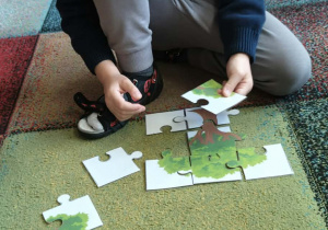 Chłopiec układa puzzle.