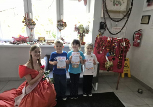dzieci w towarzystwie Królowej Róż pozują do zdjęcia trzymając dyplomy