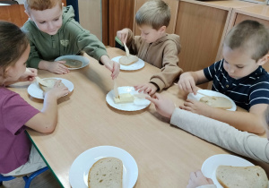 Dzieci smarują kanapki masłem