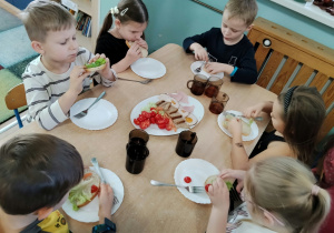 Dzieci jedzą zrobione przez siebie kanapki